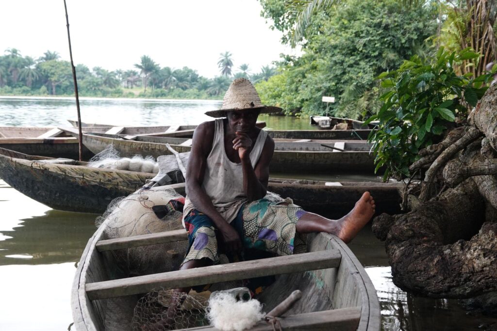 [PHOTO : Le pêcheur Nombare Tabu assis dans sa pirogue sur le ruisseau Nweemuu, à Bodo. Pulitzer / AnuOluwapo Adelakun]